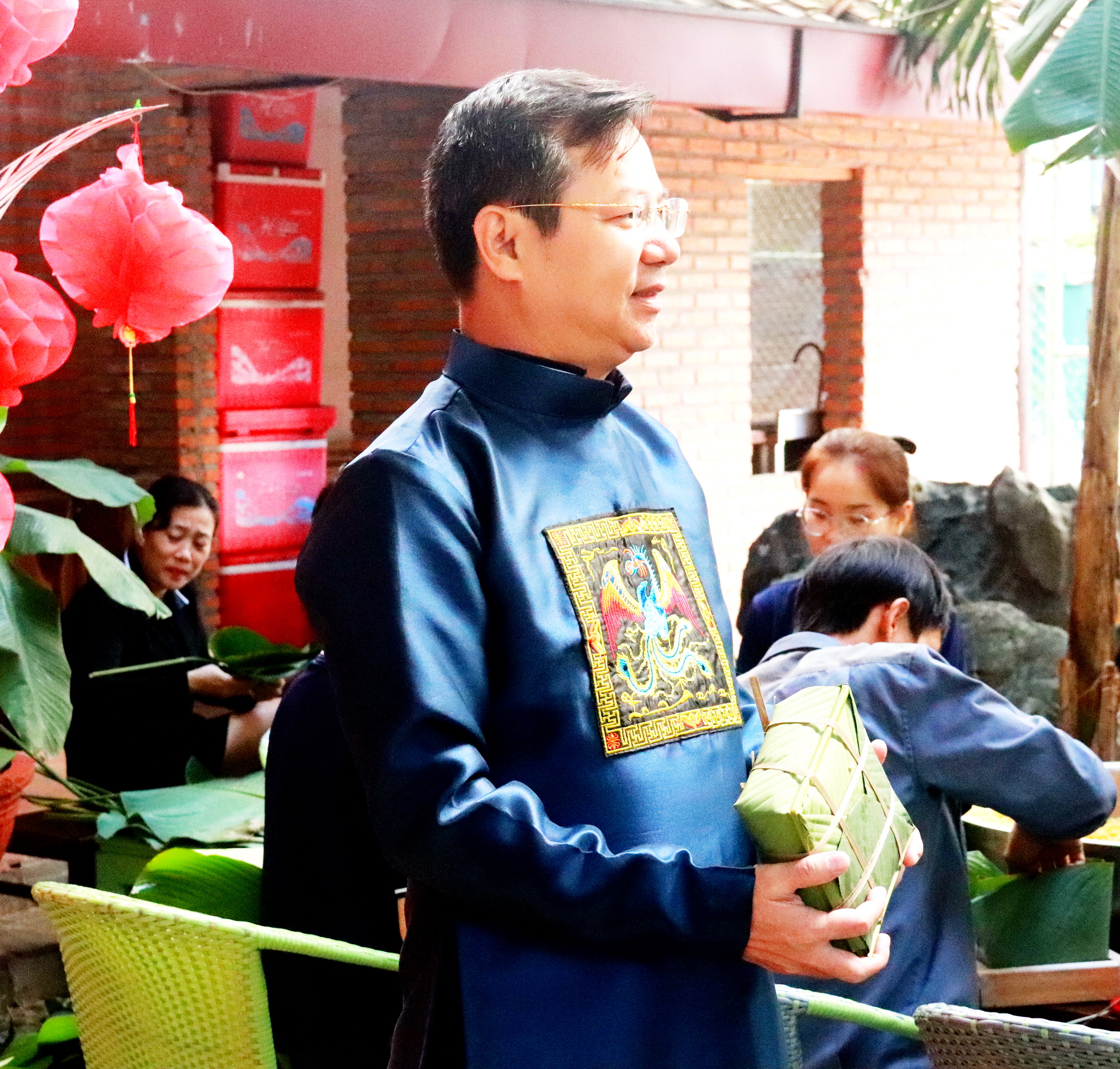 Ông Trần Tấn Ngọc cầm trên tay chiếc bánh chưng do chính tay ông tự gói.